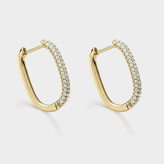 Kreolische Ohrringe aus gelbvergoldetem Silber in ovaler Form mit weißen Zirkonen in der Mitte ihrer Ellipse.