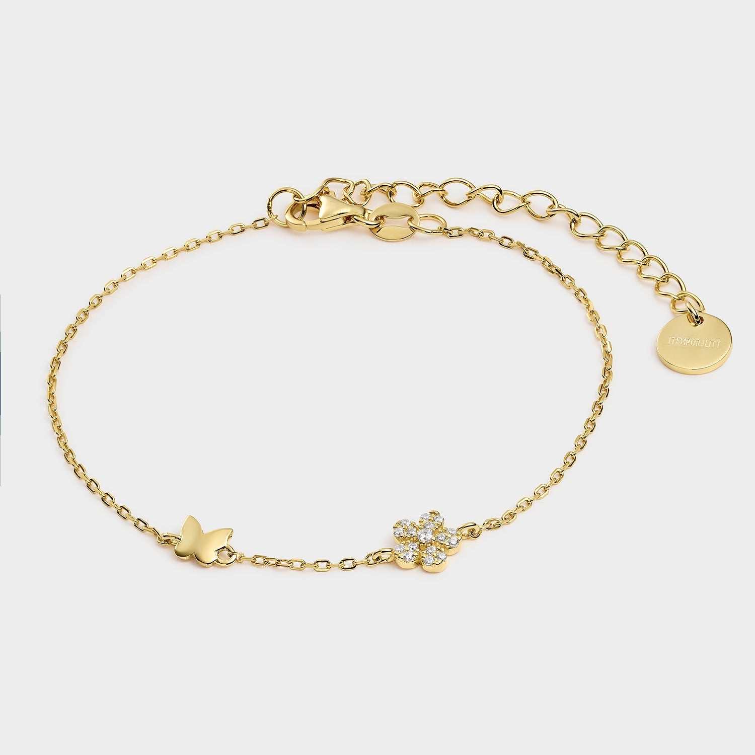 Pulsera de plata bañada en oro amarillo con motivo de mariposa y flor con circonitas blancas