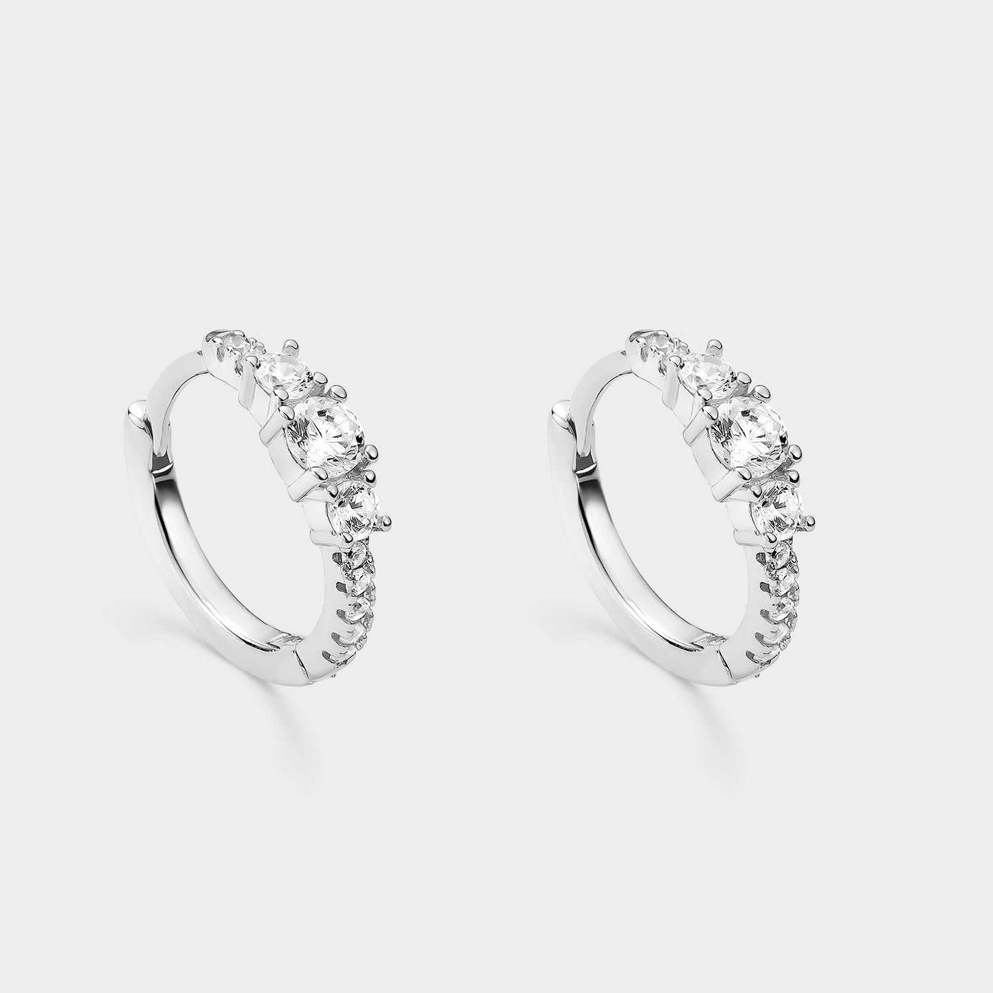 Creole silver earrings with white zircons of different sizes