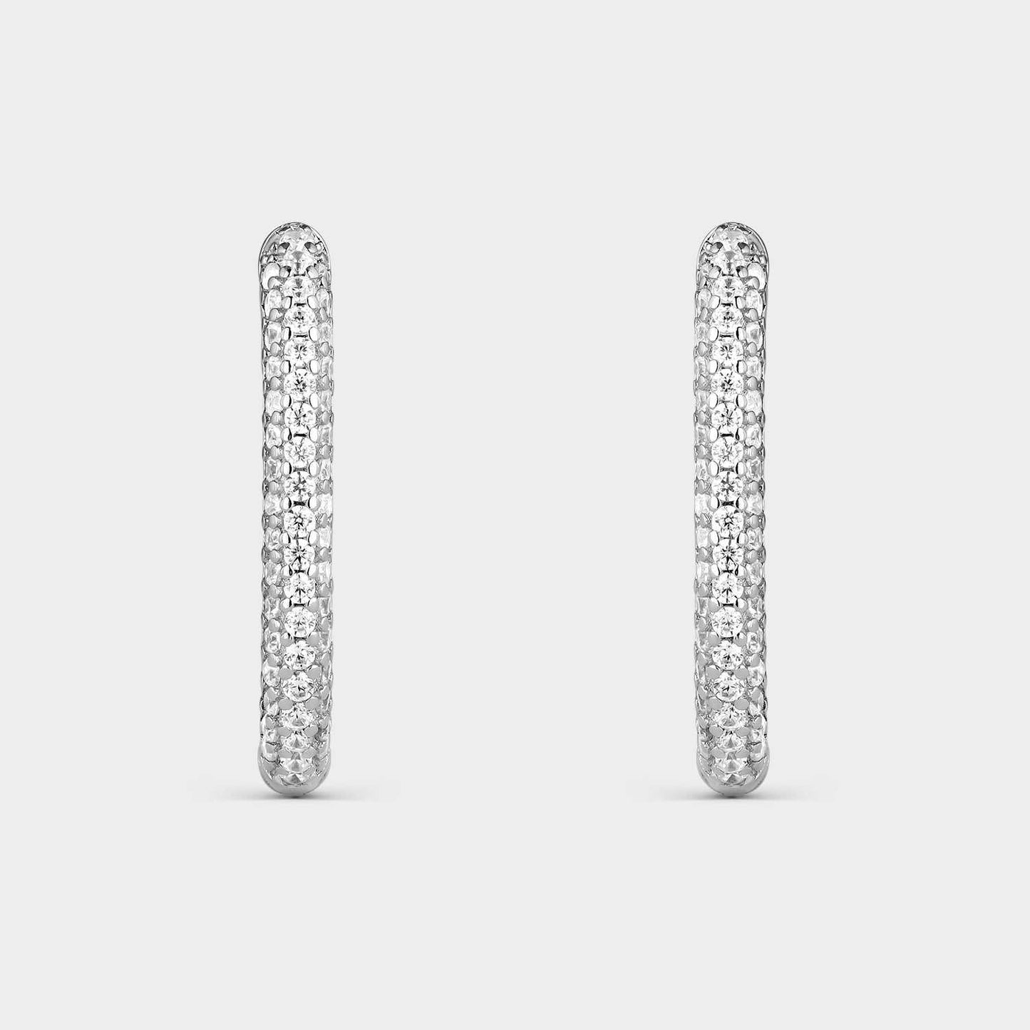 Pendientes criollas de plata con forma oval con  circonitas blancas en la mitad de su elipse.