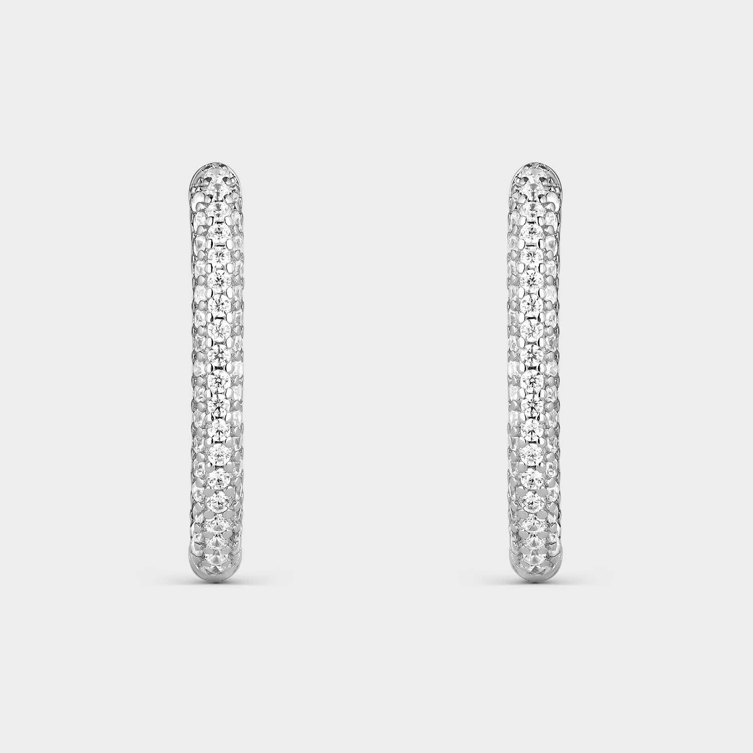 Pendientes criollas de plata con forma oval con  circonitas blancas en la mitad de su elipse.