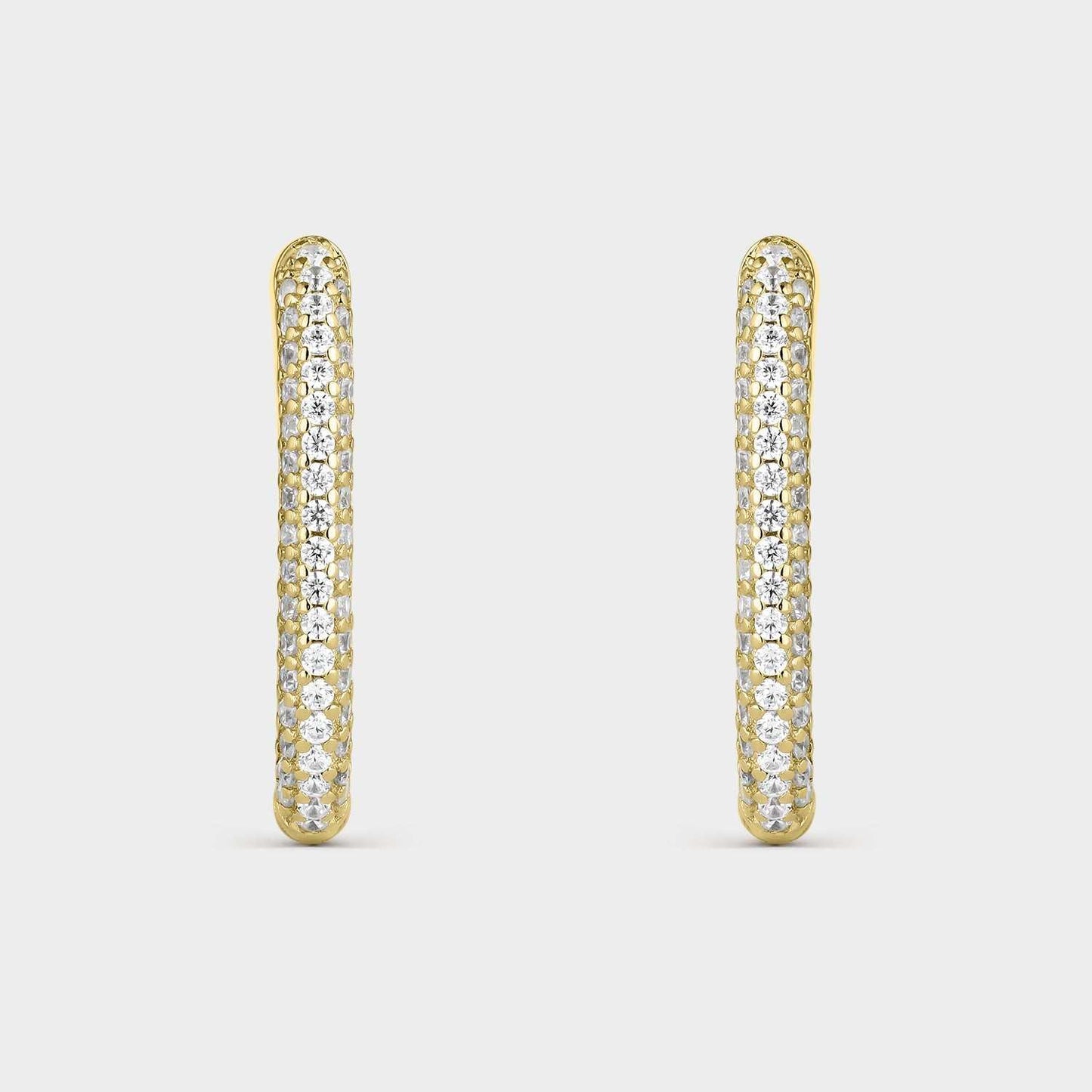 Pendientes criollas de plata bañada en oro amarillo con forma oval con  circonitas blancas en la mitad de su elipse.