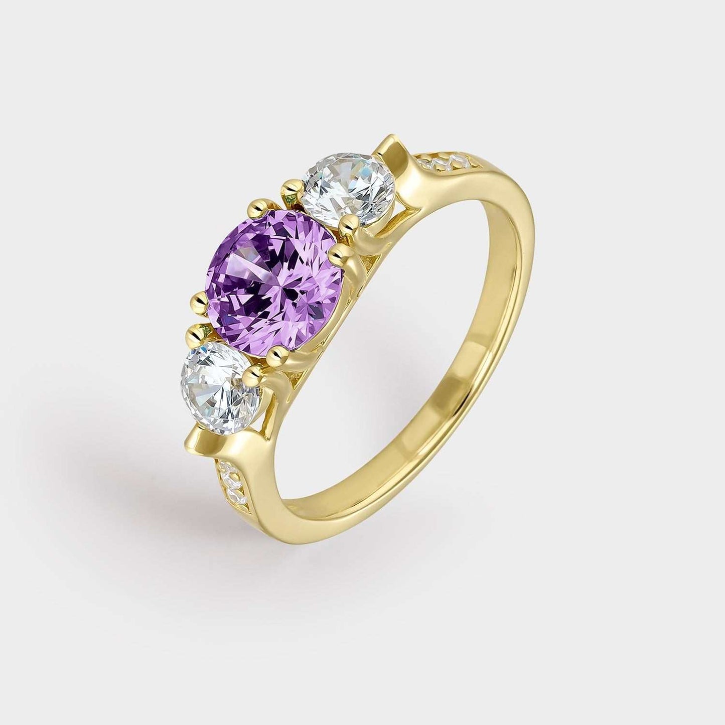 Anillo de plata bañada en oro amarillo con dos circonitas blancas y circonita central de mayor tamaño color amatista.