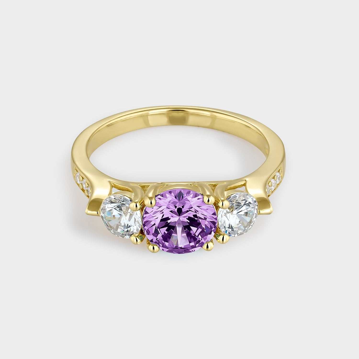 Anillo  de plata bañada en oro amarillo con dos circonitas blancas y circonita central de mayor tamaño color amatista.